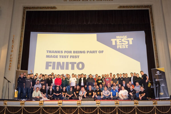 A big group of people stand on a stage in front of a screen that reads Mage Test Fest, Thanks for being part of Mage Test Fest. Finito.