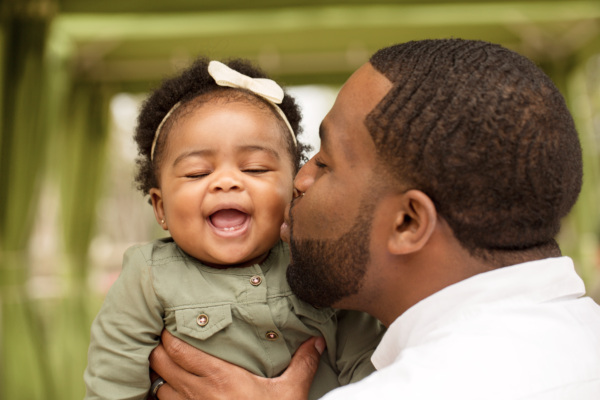 Man kisses a smiling baby