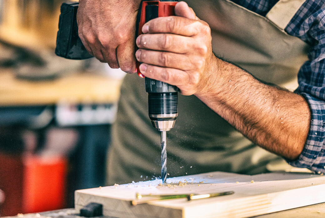 Man drill wood with a power drill