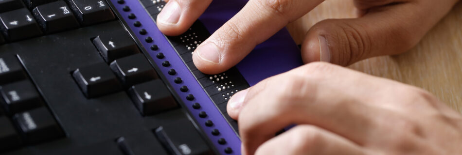 Closeup of person using braille keyboard
